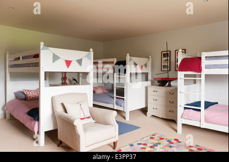 Lits superposés en bois blanc avec chambre à coucher de childrens en fauteuil et décoratives bunting Banque D'Images