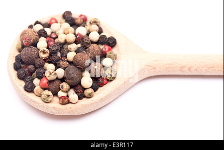 Mélange de poivrons de couleur sur une cuillère en bois isolé sur blanc Banque D'Images