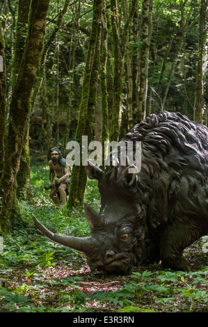 Chasse chasseur néanderthal rhinocéros laineux (Coelodonta antiquitatis) à Préhisto Parc sur la vie préhistorique à Tursac, France Banque D'Images