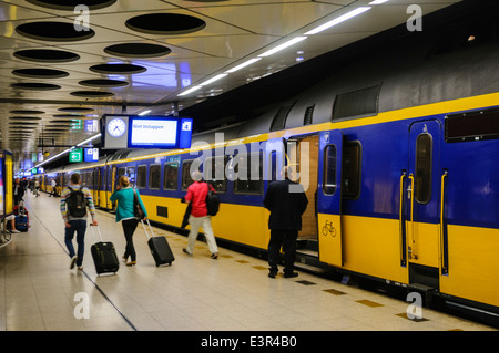 Les passagers descendre d'un train à l'aéroport d'Amsterdam-Schiphol Banque D'Images