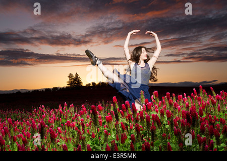 Ballerine danser dans un champ de trèfle au coucher du soleil Banque D'Images