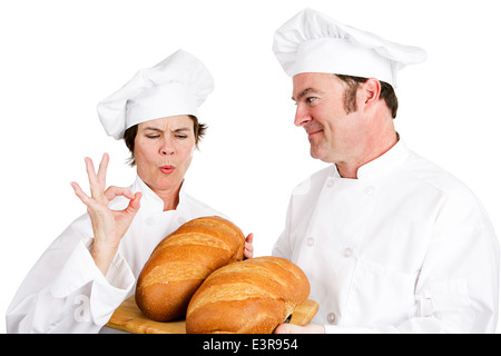 Maître boulanger compliments un chef stagiaire sur sa parfaite miches de pain. Isolé sur blanc. Banque D'Images