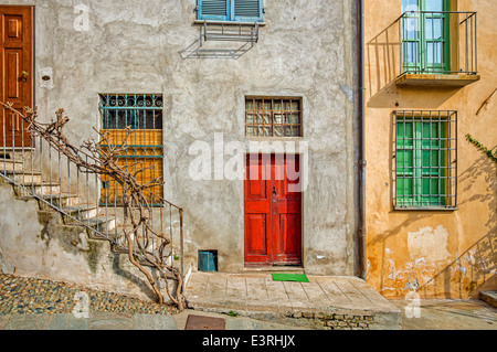 Façade de maison typiquement italien avec des fenêtres et des portes de la ville de Saluzzo en Piémont, Italie du Nord. Banque D'Images