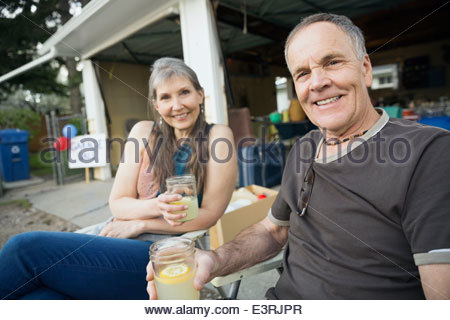 Portrait de couple drinking lemonade extérieur garage Vente