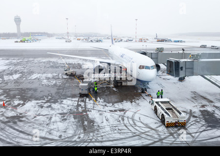 SAINT-Pétersbourg, Russie - le 19 mars 2014 : l'aéroport de neige, avion, personnel et service voitures Banque D'Images