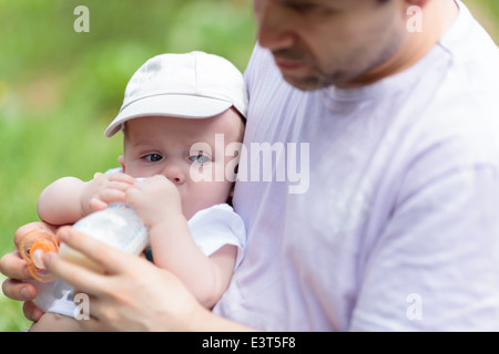 Père à nourrir ses bébé de la bouteille Banque D'Images