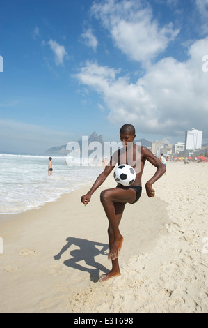 RIO DE JANEIRO, Brésil - Mars 2011 : Jeune homme Brésilien participe à un jeu de football de plage kickups sur la plage d'Ipanema, Banque D'Images