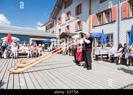 En suisse des musiciens jouant le costume national traditionnel alpenhorn dans Mont Männlichen, Wengen, Oberland Bernois, Suisse Banque D'Images