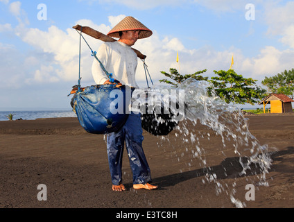 L'un des rares fabricants de sel traditionnel de Bali, à Kusamba Beach. Bali, Indonésie. Banque D'Images