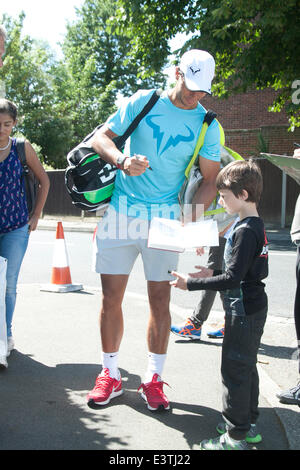 Wimbledon Londres, Royaume-Uni. 29 juin 2014. Rafael Nadal signe pour un jeune chasseur d'autographes comme arrive pour la pratique du tennis sur milieu dimanche, à l'All England Club Crédit : amer ghazzal/Alamy Live News Banque D'Images