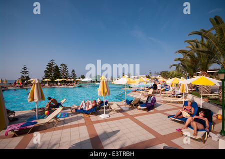 Les gens en vacances en profitant du soleil dans et autour de la piscine de l'hôtel Iberostar Creta Marine Panormo Crète Banque D'Images