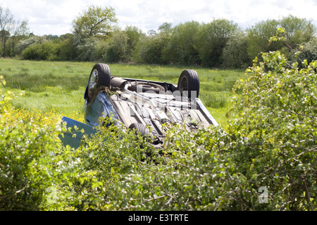 Voiture roulé dans une prairie de renoncule après l'accident de la route Banque D'Images