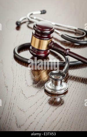 Gavel and Stethoscope on Reflective Table en bois. Banque D'Images