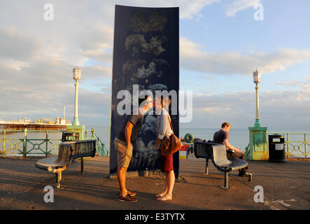 Brighton, Sussex, UK. 29 Juin, 2014. Un couple de voler un baiser par la statue de baisers sur le front de mer de Brighton à la fin d'une autre journée chaude sur la côte sud Photo prise par Simon Dack/Alamy Live News Banque D'Images