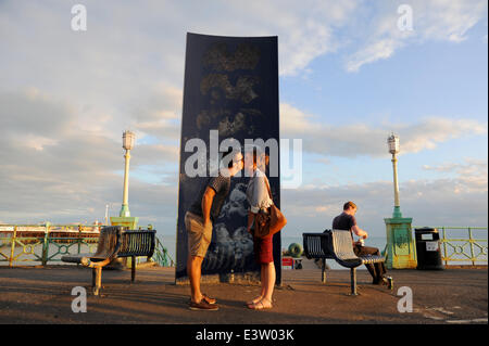 Brighton, Sussex, UK. 29 Juin, 2014. Un couple de voler un baiser par la statue de baisers sur le front de mer de Brighton à la fin d'une autre journée chaude sur la côte sud Photo prise par Simon Dack/Alamy Live News Banque D'Images