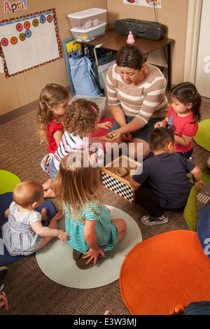 Un enseignant montre hispaniques des nids d'oiseau pour les jeunes enfants à l'apprentissage d'un 'lien' en classe Tustin, CA, à réaliser un atelier interactif dans le comportement. À l'aide d'activités spécialement conçues, la classe enseigne aux parents comment faire participer leurs enfants à jouer utile. Notez dans la case des œufs artificiels. Banque D'Images