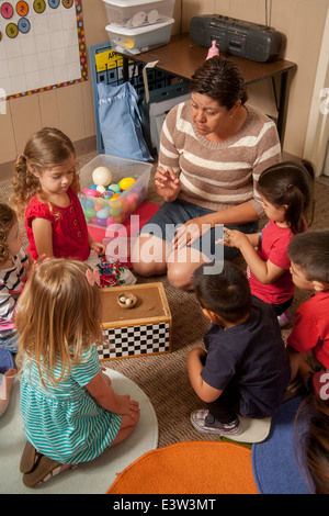 Un enseignant montre hispaniques des nids d'oiseau pour les jeunes enfants à l'apprentissage d'un 'lien' en classe Tustin, CA, à réaliser un atelier interactif dans le comportement. À l'aide d'activités spécialement conçues, la classe enseigne aux parents comment faire participer leurs enfants à jouer utile. Notez dans la case des œufs artificiels. Banque D'Images