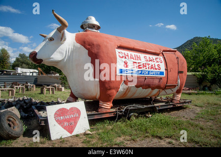 Un énorme fake vache sur une remorque porte un panneau publicitaire dans la région de Lone Pine, CA. Remarque porte et ventilateur. Banque D'Images