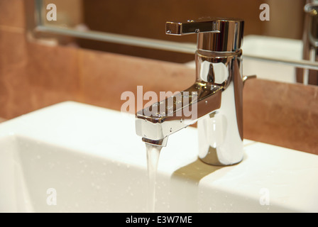 Robinet d'eau en acier inoxydable dans une salle de bain Banque D'Images