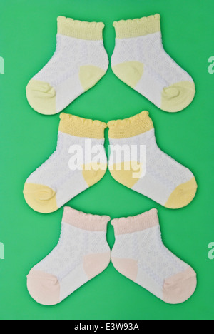 Trois paires de chaussettes bébé sur fond vert Banque D'Images