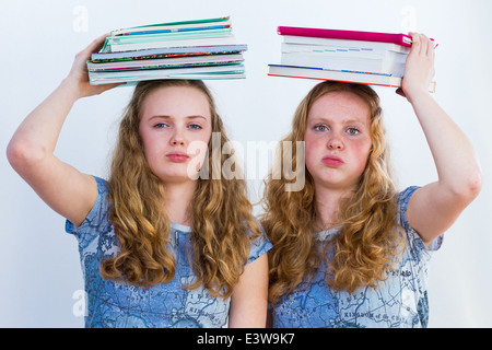 Deux écolières avec les manuels scolaires sur leurs têtes Banque D'Images