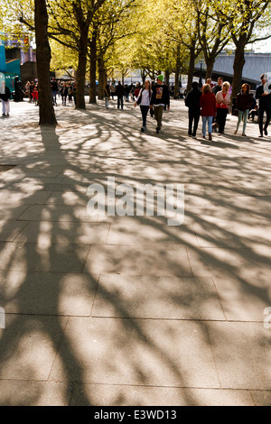 Young couple holding hands, marcher dans shot sur London's South Bank un jour de printemps. Banque D'Images