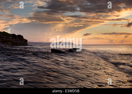 Dalle calcaire exposés par marée descendante sur une soirée d'été. Plage entre Kilve et East Quantoxhead. Banque D'Images