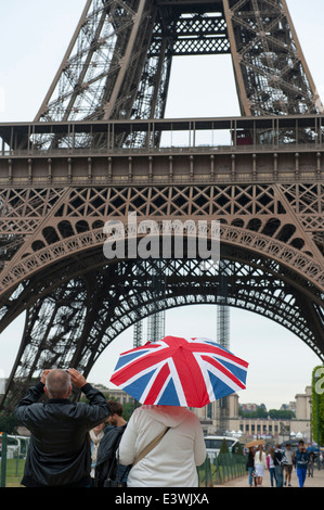 Les touristes anglais à paris photographier la tour eiffel avec union jack dans la pluie parapluie Banque D'Images