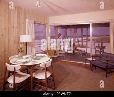 Ce titre fait référence au style de design de Joseph Janney Steinmetz, figure éminente du design d'intérieur moderne du milieu du siècle. L'accent est mis sur un intérieur de chalet à Sarasota, en Floride, avec des lambris de bois, une caractéristique commune du design moderne du milieu du siècle. Le thème des vacances suggère que cet espace a été conçu pour les loisirs et la détente, aligné avec les tendances du milieu du siècle dans les chalets de Floride. Banque D'Images