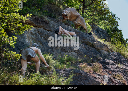 Eurasian lion des cavernes (Panthera leo spelaea) Charge au garçon de Cro-Magnon Préhisto Parc sur la vie préhistorique à Tursac, France Banque D'Images