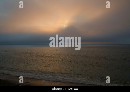 Soleil du soir à travers les nuages sur le fleuve Saint-Laurent, dans le parc provincial de Forillon, en Gaspésie, au Québec, Canada. Banque D'Images