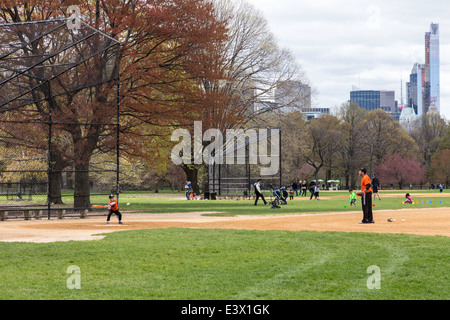Père jouer au baseball avec les petits fils, grande pelouse, Central Park, NYC, USA Banque D'Images
