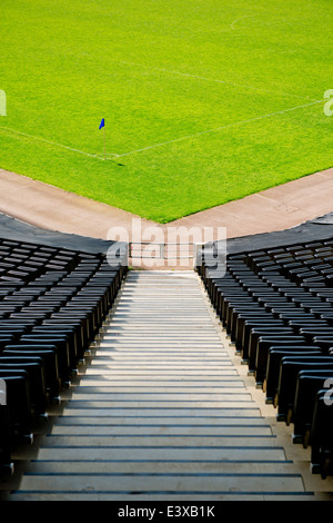 Des rangées de sièges vides pour les spectateurs à un terrain de football. Banque D'Images