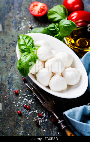 La mozzarella avec tomates et basilic Feuilles sur fond de bois Banque D'Images