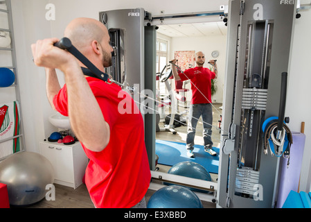 Un physiothérapeute montre un exercice qui renforce la colonne vertébrale et les muscles du dos. Banque D'Images