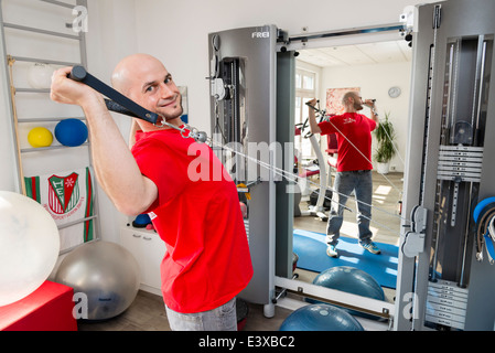 Un physiothérapeute montre un exercice qui renforce la colonne vertébrale et les muscles du dos. Banque D'Images