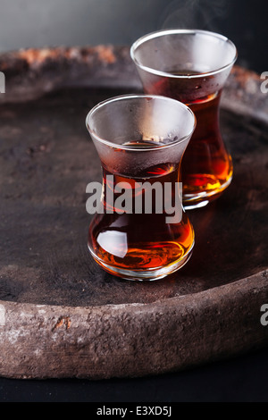 Le thé chaud dans la tasse de thé turc sur fond sombre Banque D'Images