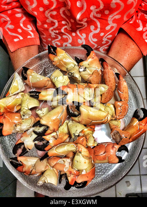 Woman holding plate of pinces de crabe Banque D'Images