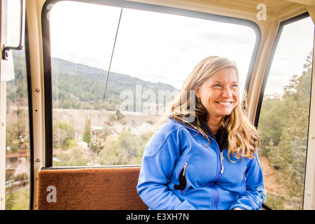 Caucasian woman riding dans aerial tram Banque D'Images