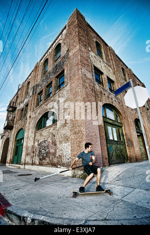 Caucasian man riding skateboard avec terrain paddle Banque D'Images