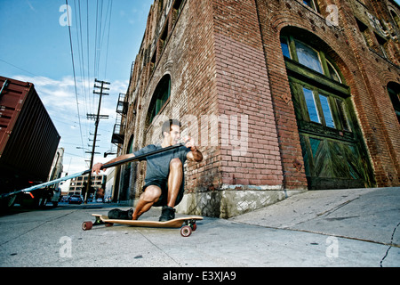 Caucasian man riding skateboard avec terrain paddle Banque D'Images