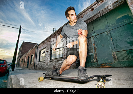 Caucasian man riding skateboard avec terrain paddle Banque D'Images