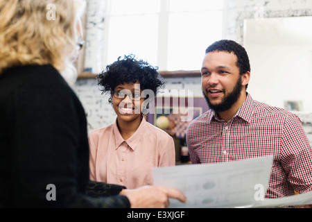 Businesswoman talking to young couple Banque D'Images