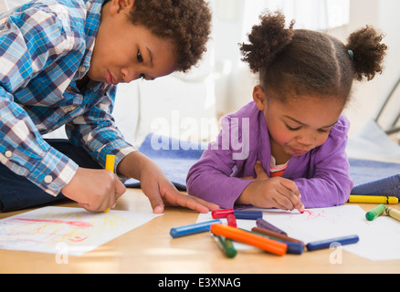 Les enfants noirs coloration sur plancher du salon Banque D'Images