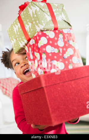 Fille noire transportant pile de cadeaux de Noël Banque D'Images