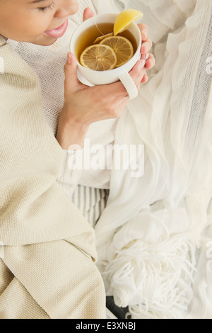 Femme noire de boire une tasse de thé au citron Banque D'Images