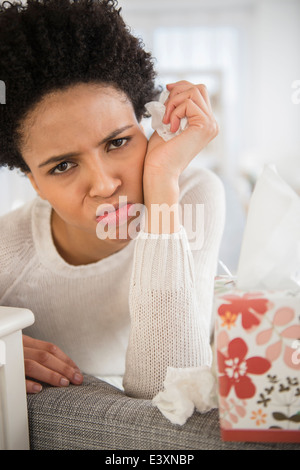 Black woman wiping son nez avec des mouchoirs Banque D'Images