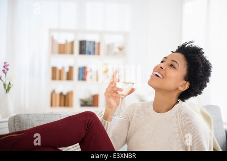 Black woman drinking wine on sofa Banque D'Images