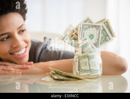 Black woman admiring économisé de l'argent dans les jar Banque D'Images