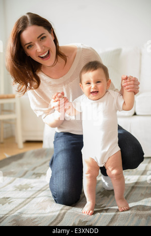 Mère d'aider bébé dans le salon stand Banque D'Images